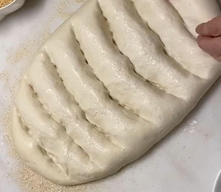 Ramazan Pidesi Tarifi - Hamuru tırnaklarken ellerinizi iyice ıslatın hamur oldukça yapışkandır. Tırnaklama yaparken tek ve eşit hareketlerle hamuru tırnaklayıp önce yatay, sonra açılı tırnaklayarak baklava deseni oluşturun